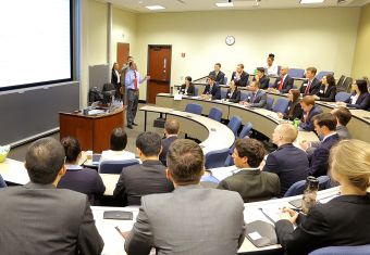 A classroom of people watching a male presenter in the front
