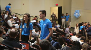 Undergraduate students stand in Koury auditorium at UNC Kenan-Flagler during Fall 2019 orientation