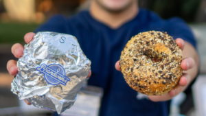 Alex Brandwein holding a bagel