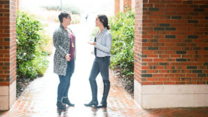 Meredith Tozzer and Becca Jordan talking in front of McColl building