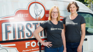 Jennifer Curtis and Tina Prevatte Levy of Firsthand Foods pose for a in front of a delivery truck