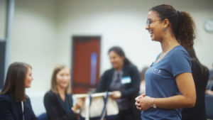 Standing at checkin table Mabel Acosta smiles at CWIB team