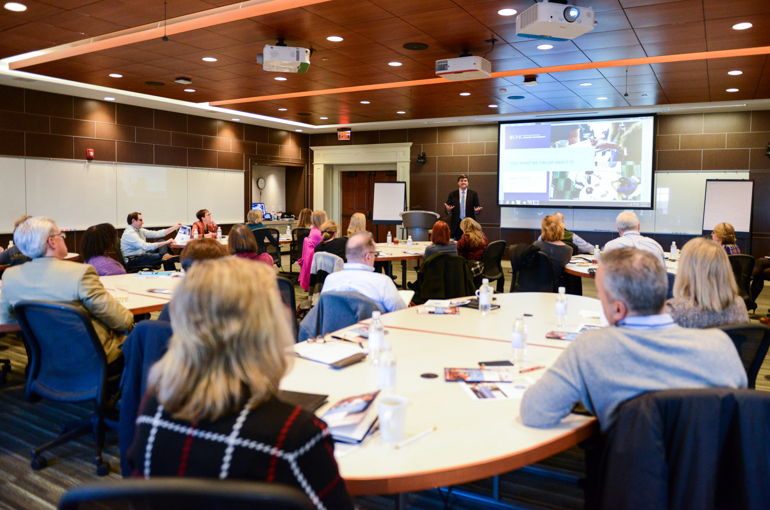 Businesspeople in a University of North Carolina at Chapel Hill classroom listening to a presenter.