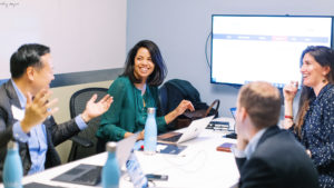 MBA@UNC Students Smiling And Talking About STAR Project At Meeting Table