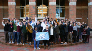 Family Enterprise Center students cheering holding flag at UNC Kenan-Flagler 2019