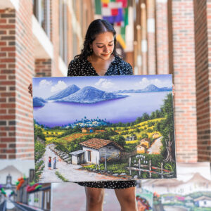 Manocha (BSBA '22) holding artwork from Guatemala