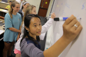 Student writing on whiteboard