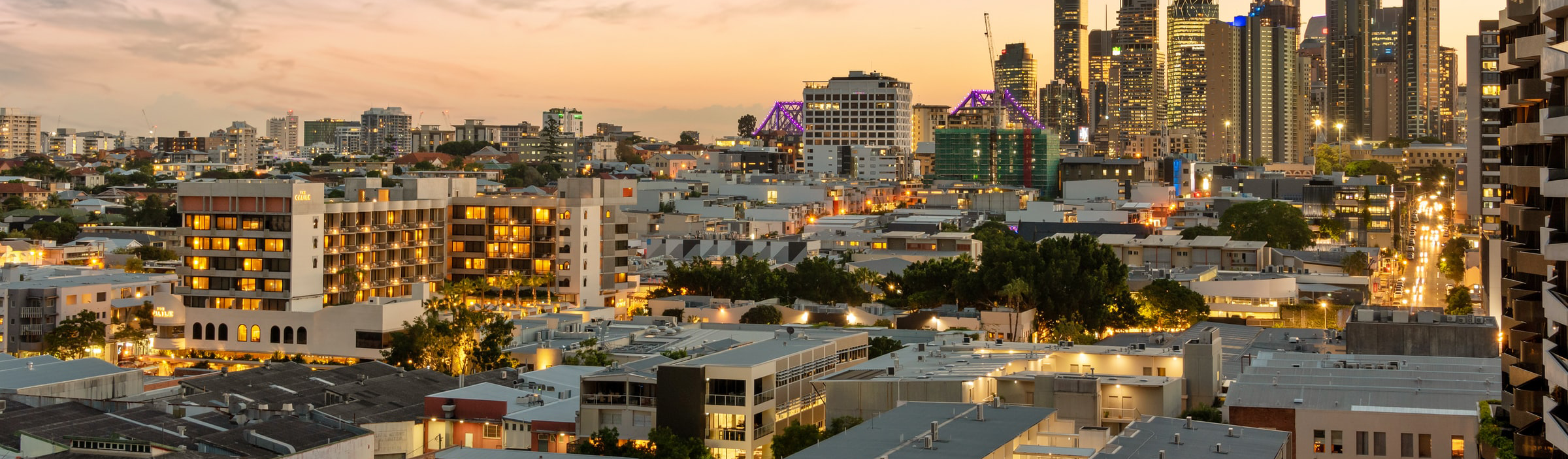 A sun sets over a city skyline.
