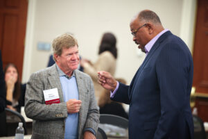 Charlie Brindell listens while Daryl Carter speaks to him at the 2022 Affordable Housing Symposium.