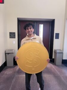 Satasia holds the giant coin.