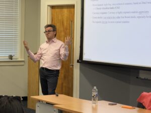 Colacito shrugs in front of a classroom.