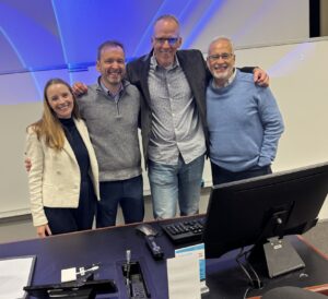 Keegan, Grannan and Asuncion pose with McNeilly at the front of the classroom.