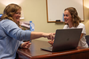 Sarah Crockett, associate director of UBP career development, points to a laptop screen while working with a student.