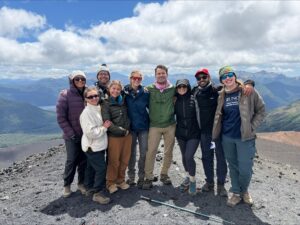 MBA students pose for a group photo on top of a black volcanic slope in Argentinian Patagonia.