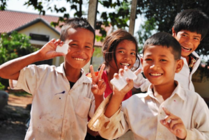 Children holding bars of soap and smiling at camera