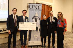 Winning Northwestern team of four poses with Hines representative with their first place oversized check.