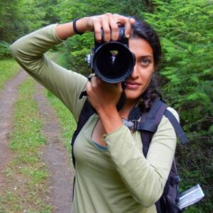 Woman holding camera pointed at viewer