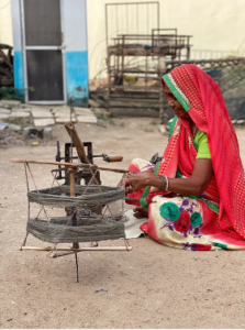 Cotton threads are woven manually on a traditional wooden hand loom.