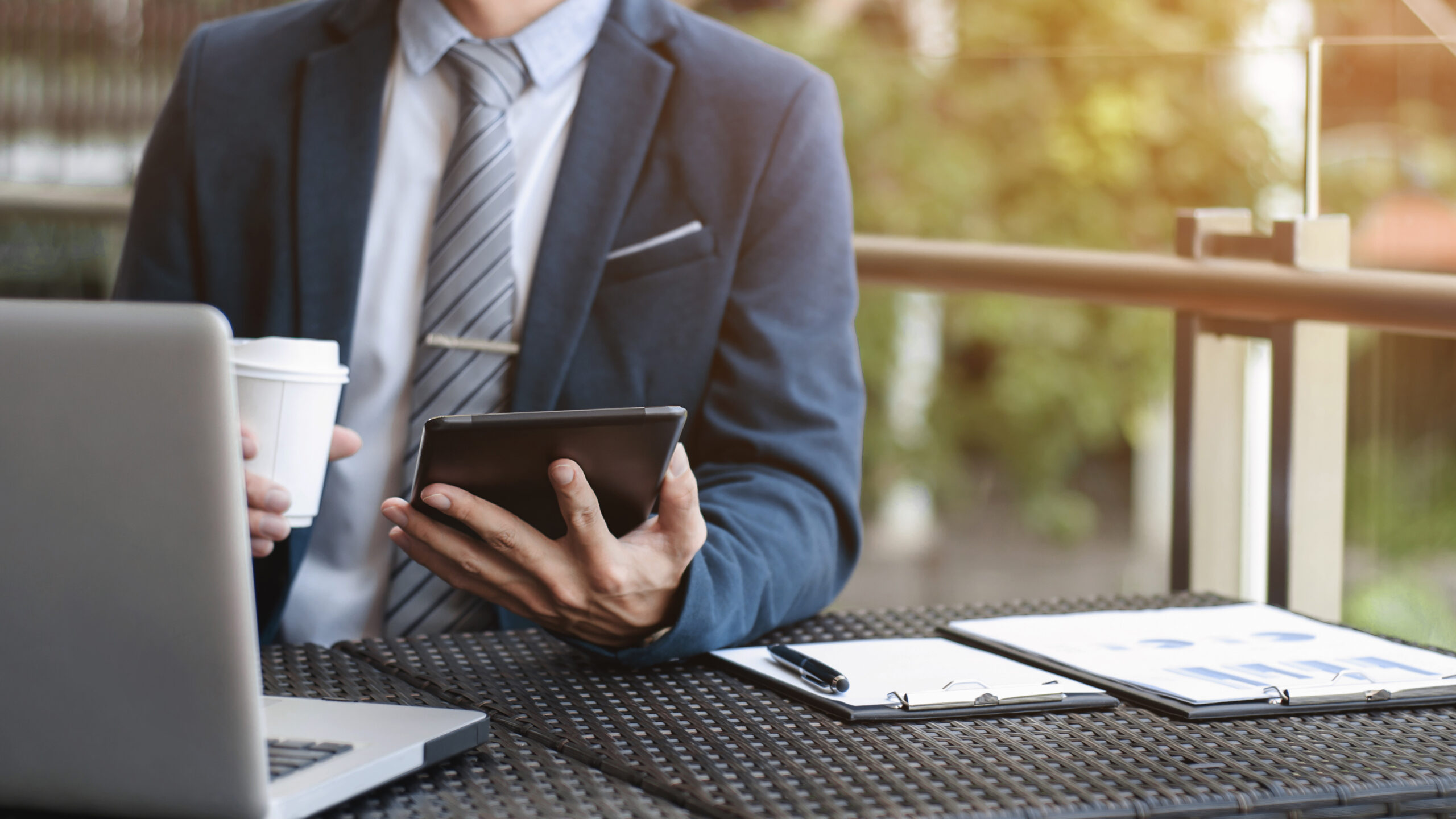 businessman working with digital tablet and laptop with financial business strategy at a coffee shop cafe