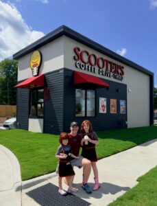 Griffin Kennedy (MAC ’13) and his children in front of their Scooter's Coffee location
