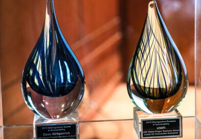 Two Sustainability Awards sitting on table engraved with winner's names.