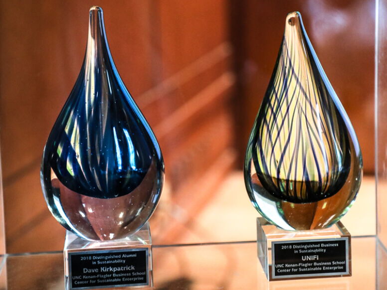 Two Sustainability Awards sitting on table engraved with winner's names.