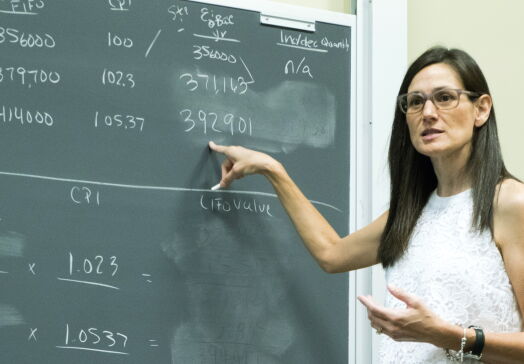 Woman pointing to math on a chalkboard