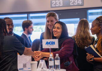 A woman at a networking event is shaking someone's hand.