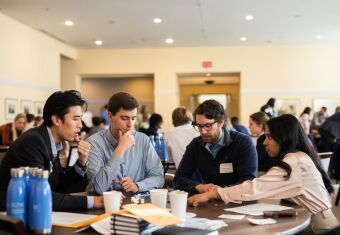 People sitting at a table collaborating on a project.