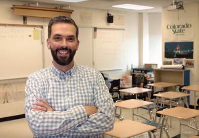 Mark Loyd standing with arms crossed in a classroom