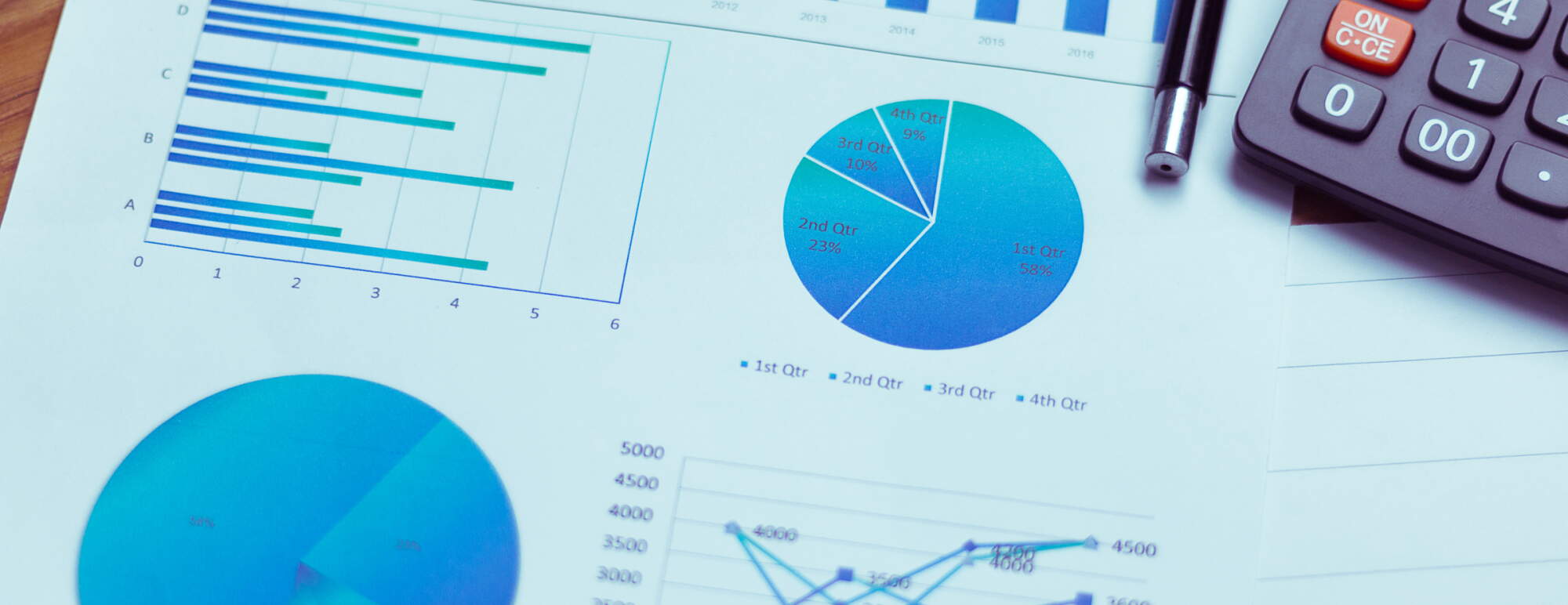 Various charts and graphs with a pen and calculator on a table