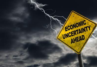 Stormy weather with a sign that reads economic uncertainty ahead.