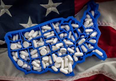 American flag with U.S. cut out and pills