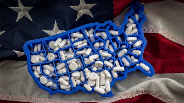 American flag with U.S. cut out and pills