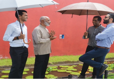 Four men standing outside under umbrellas and talking