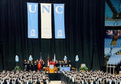 Students stand at graduation ceremony at UNC Kenan-Flagler