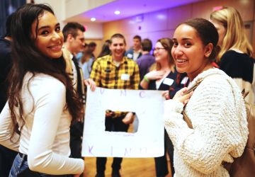 Undergraduate students stand in Koury auditorium at UNC Kenan-Flagler during Fall 2019 orientation