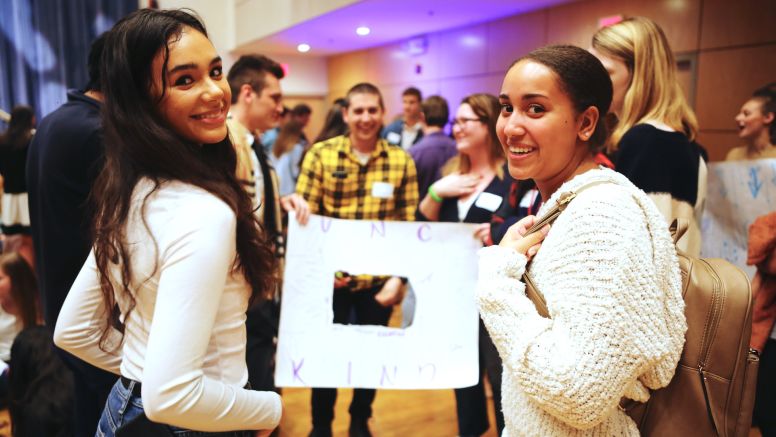 Undergraduate students stand in Koury auditorium at UNC Kenan-Flagler during Fall 2019 orientation