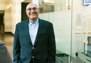 Professor Arv Malhotra stands in front of Kenan-Flagler McColl building