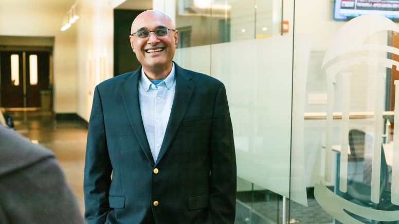 Professor Arv Malhotra stands in front of Kenan-Flagler McColl building