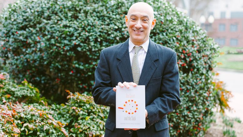 William Putsis holding his new book The Carrot And The Stick Book at UNC Kenan-Flagler