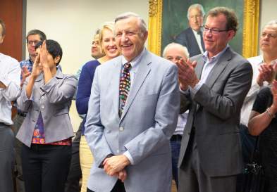 Doug Elvers Surrounded by Clapping Faculty at UNC Kenan-Flagler