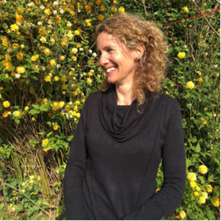 Jo Hand smiling in front of flowers