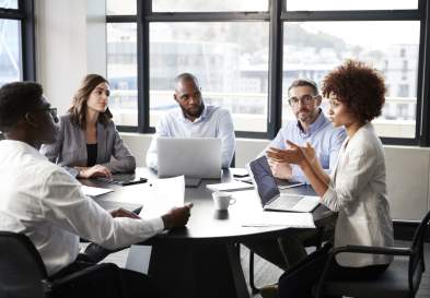 Millennial black businesswoman addressing colleagues at a corporate business meeting, close up