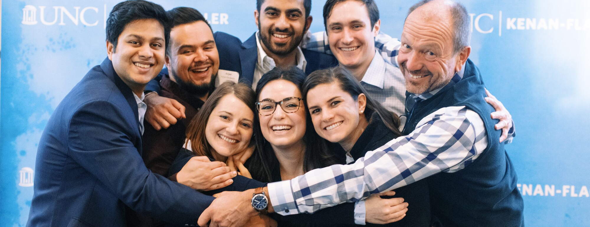 STAR students and faculty group hug at event