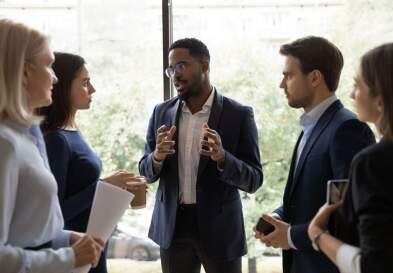 A businessman speaking to a small group of businesspeople.
