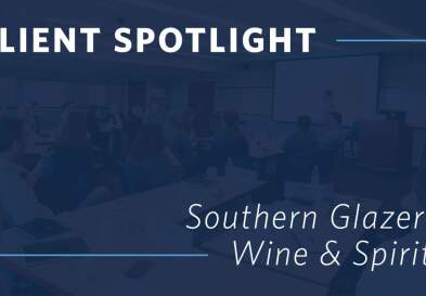 Graphic showing the words “Client Spotlight: Southern Glazer’s Wine & Spirits” overlaid on an image of businesspeople in a conference room during a presentation.