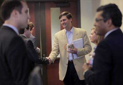 UNC professor Brad Staats shaking a businessperson's hand.