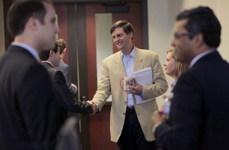 UNC professor Brad Staats shaking a businessperson's hand.