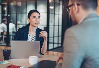 Photo of businesswoman speaking to a male colleague.